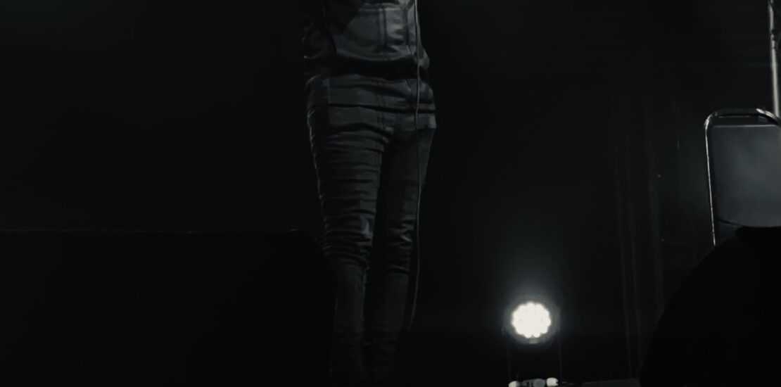Majid standing on stage with a mic, black and white image.